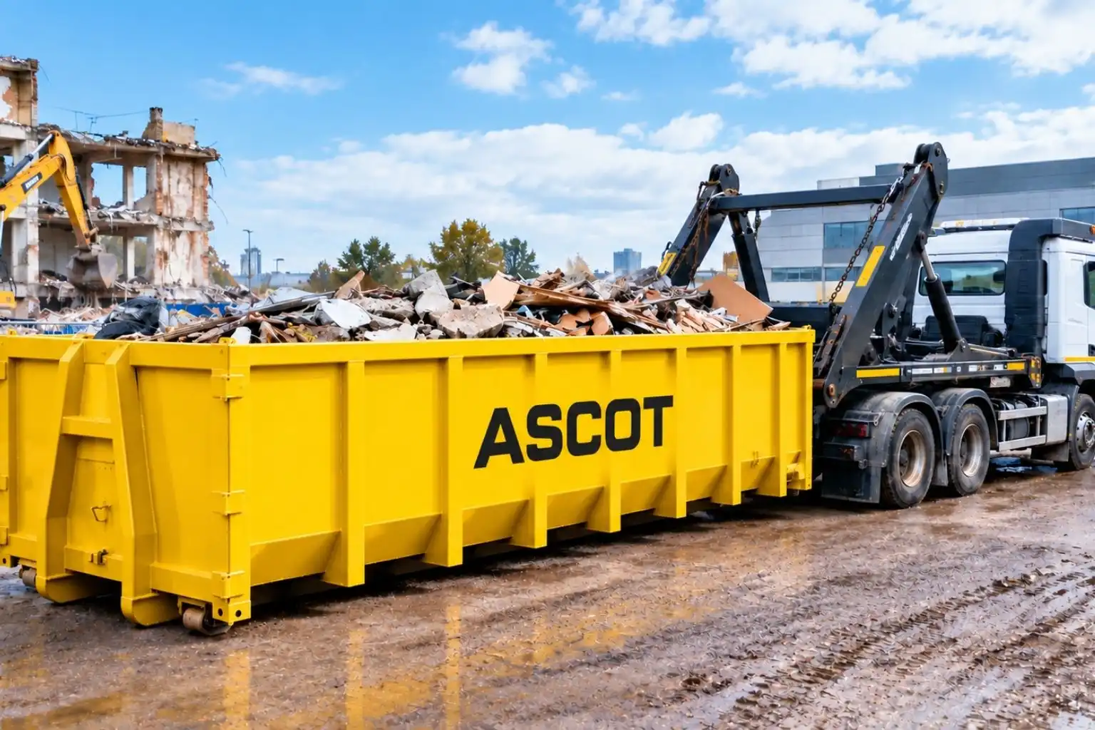 Yellow Ascot roro skip filled with demolition rubble beside a hook loader lorry